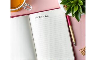 Open notebook with 'Wellness Tips' heading and a pen