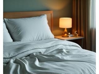 A serene bedroom scene with soft, dim lighting, inviting bed, and a digital alarm clock showing early morning, suggesting optimal sleep environment.